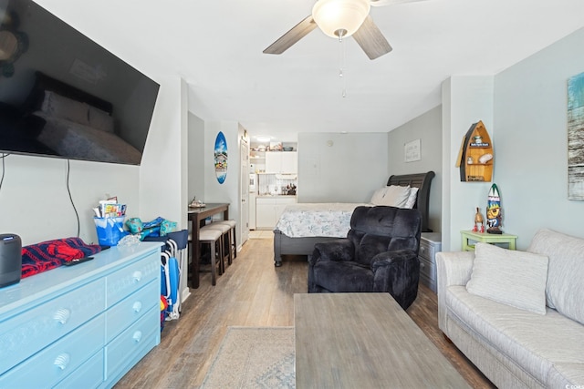 bedroom featuring wood finished floors, ceiling fan, and ensuite bath
