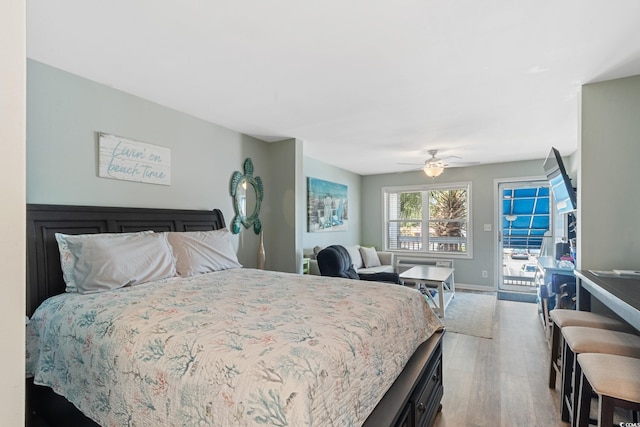 bedroom with wood finished floors, access to exterior, ceiling fan, and baseboards
