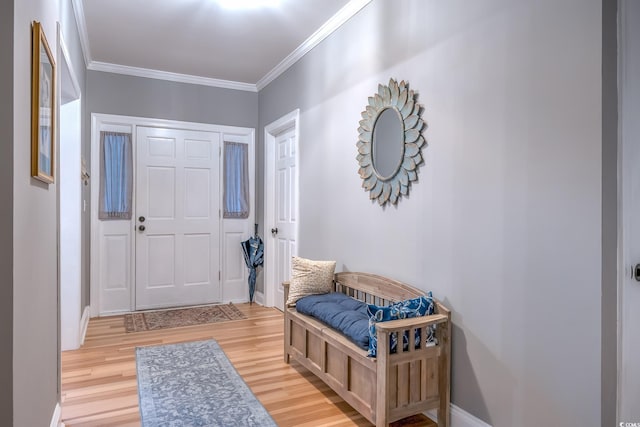 foyer entrance featuring light wood-style floors, baseboards, and crown molding