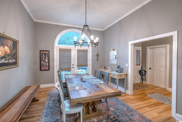dining room featuring an inviting chandelier, ornamental molding, french doors, and light wood finished floors