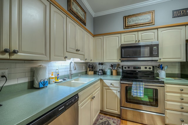kitchen with appliances with stainless steel finishes, a sink, light countertops, backsplash, and ornamental molding