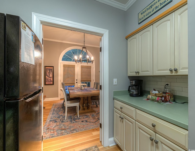 kitchen with decorative backsplash, french doors, freestanding refrigerator, light wood finished floors, and ornamental molding