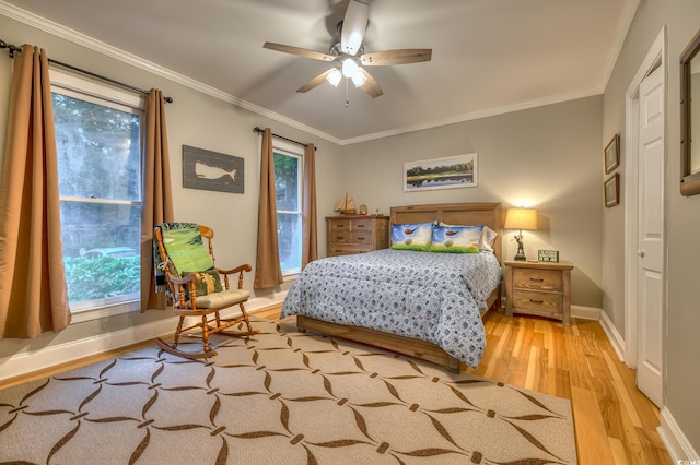 bedroom featuring baseboards, ornamental molding, ceiling fan, and light wood-style floors