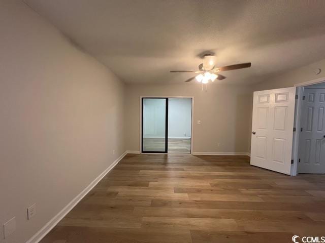 unfurnished room with ceiling fan, baseboards, and wood finished floors