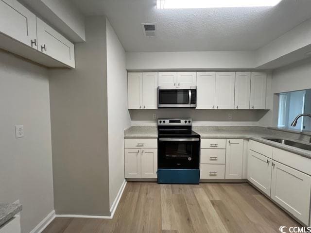 116 Hickory Dr, Conway, SC 29526 - kitchen with white cabinetry, appliances with stainless steel finishes, light wood-style flooring, and a sink