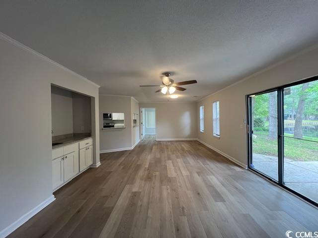 116 Hickory Dr, Conway, SC 29526 - unfurnished living room with ornamental molding, baseboards, a ceiling fan, and wood finished floors