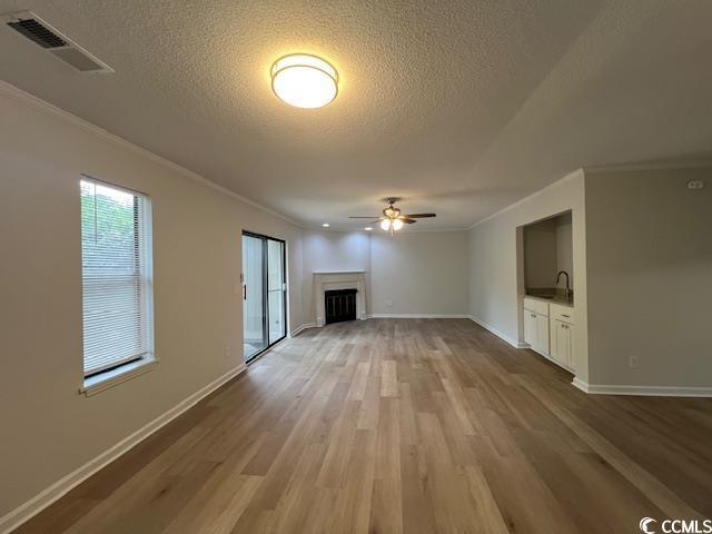 116 Hickory Dr, Conway, SC 29526 - unfurnished living room with ceiling fan, ornamental molding, visible vents, and wood finished floors
