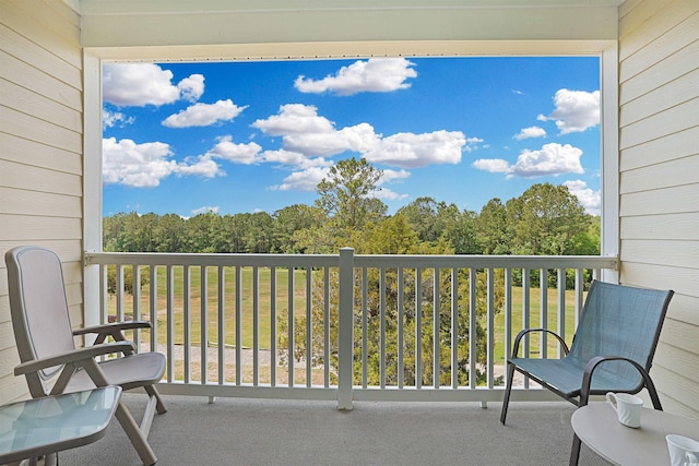 balcony featuring a wooded view