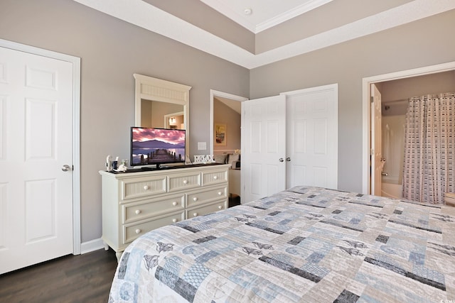 bedroom featuring baseboards, ornamental molding, dark wood-style floors, and connected bathroom