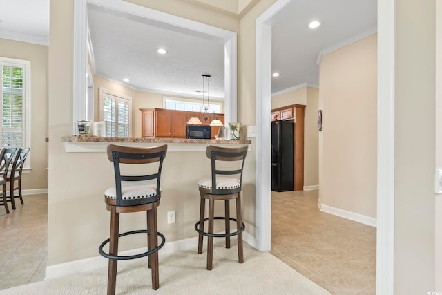 127 Willow Bay Dr, Murrells Inlet, SC 29576 - kitchen featuring a healthy amount of sunlight, brown cabinetry, crown molding, black appliances, and a breakfast bar