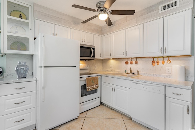 kitchen with white appliances, a sink, white cabinets, a ceiling fan, and light tile patterned floors