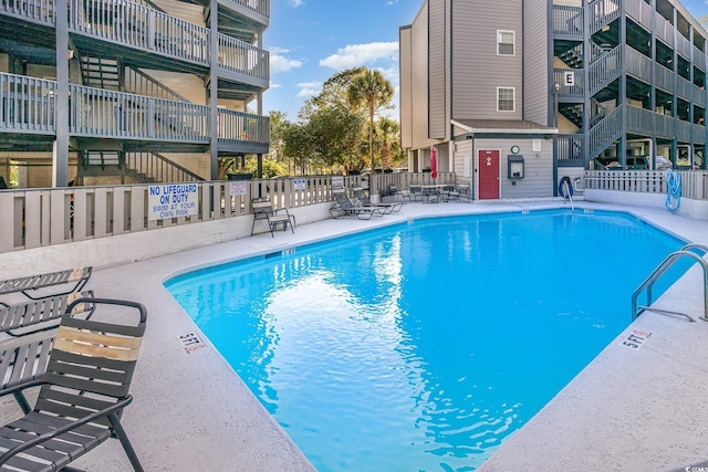 community pool with fence and a patio