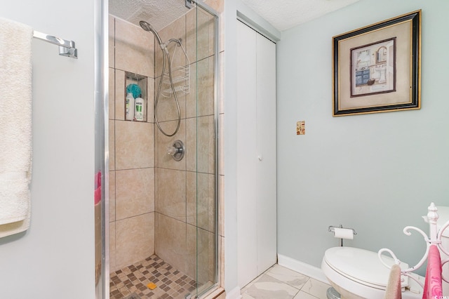 bathroom featuring a stall shower, marble finish floors, a textured ceiling, and toilet