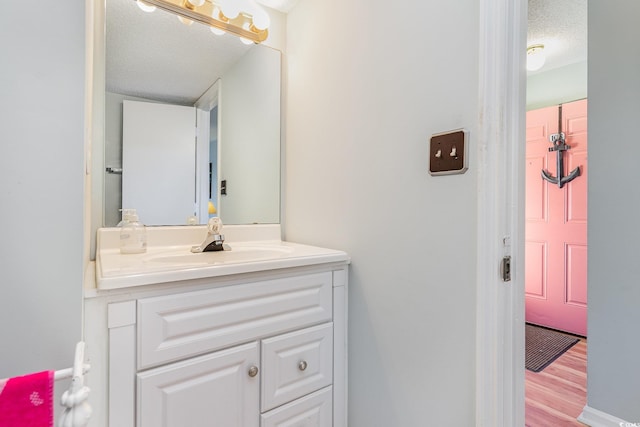 bathroom featuring wood finished floors, vanity, and a textured ceiling
