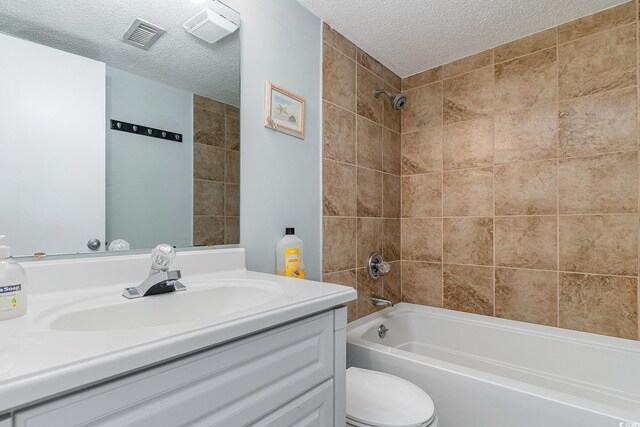 full bath with a textured ceiling, tub / shower combination, vanity, and toilet