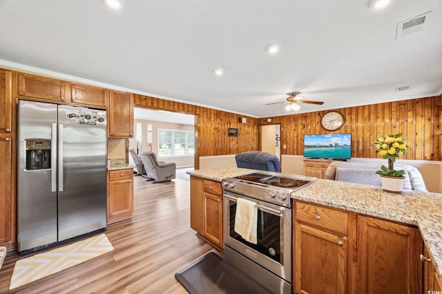 153 Busbee St, Conway, SC 29526 - kitchen featuring stainless steel appliances, open floor plan, light wood-type flooring, wooden walls, and a ceiling fan