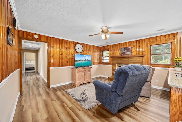 153 Busbee St, Conway, SC 29526 - living area featuring light wood-type flooring, a ceiling fan, ornamental molding, wooden walls, and attic access