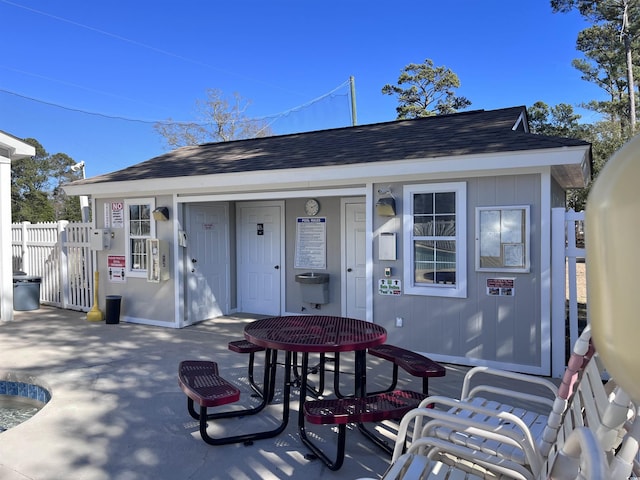 exterior space featuring fence, a patio area, and roof with shingles