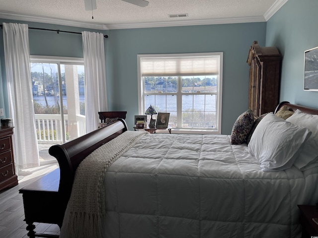 bedroom featuring visible vents, crown molding, wood finished floors, and multiple windows