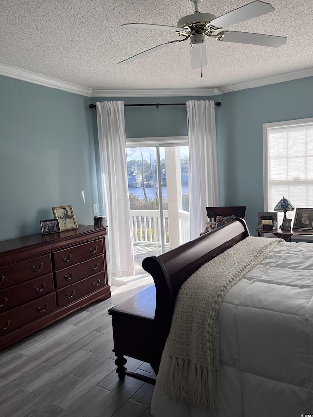 bedroom featuring crown molding, a textured ceiling, wood finished floors, and access to exterior
