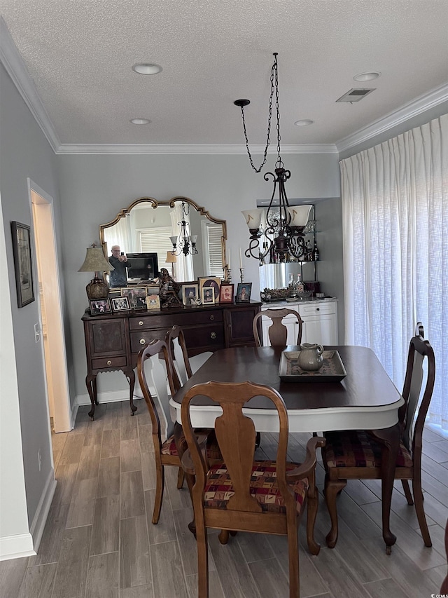 dining space with baseboards, crown molding, and wood finish floors