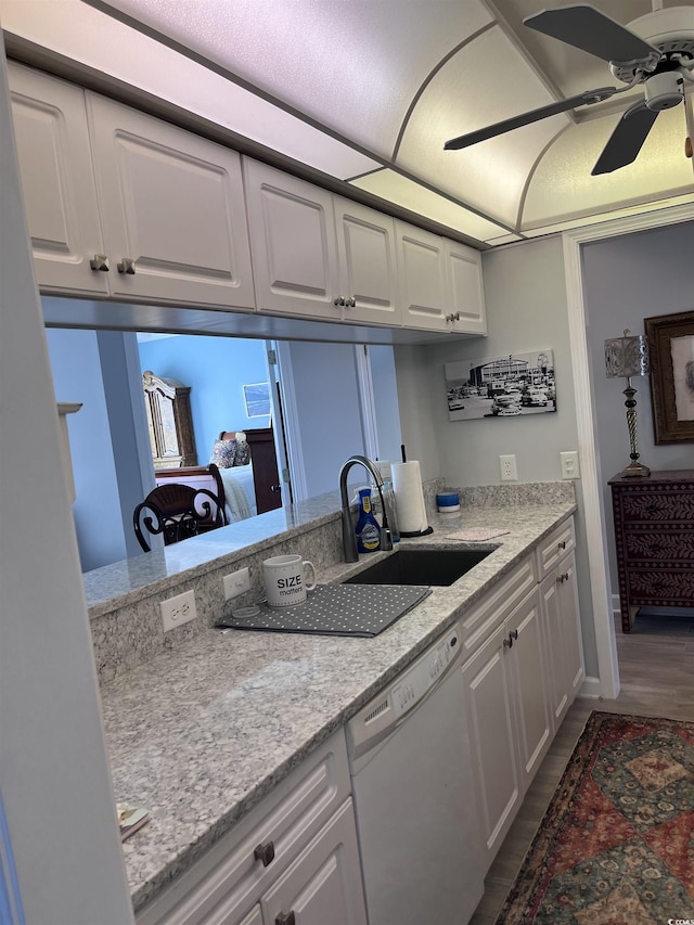 kitchen featuring ceiling fan, white dishwasher, a sink, dark wood-style floors, and white cabinetry