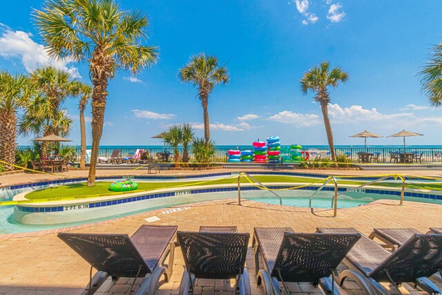 community pool featuring a patio and a water view