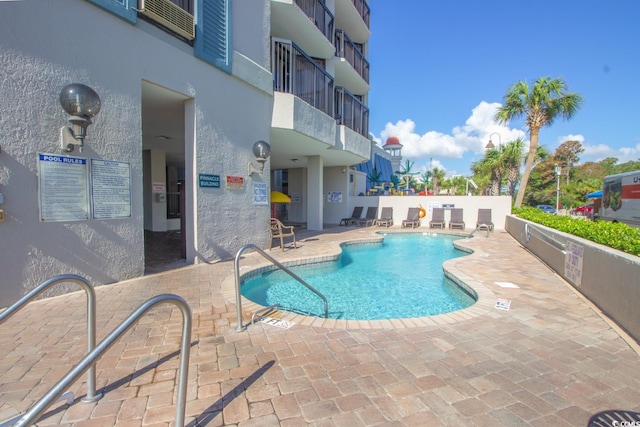 pool featuring fence and a patio area