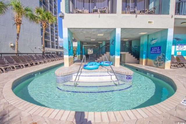 pool featuring stairway and a patio