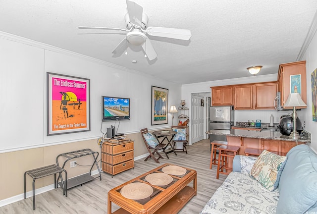 4516 Seaview St Unit 135, North Myrtle Beach, SC 29582 - living room featuring ornamental molding, light wood-type flooring, ceiling fan, and a textured ceiling