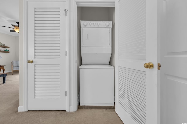 laundry area featuring laundry area, carpet flooring, a ceiling fan, and stacked washer / drying machine