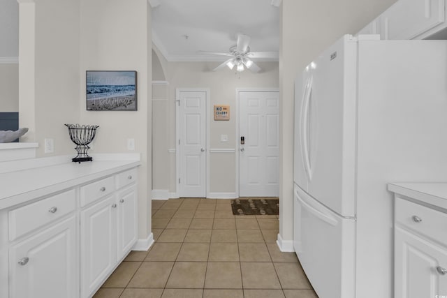 kitchen featuring freestanding refrigerator, light tile patterned flooring, ceiling fan, light countertops, and white cabinetry