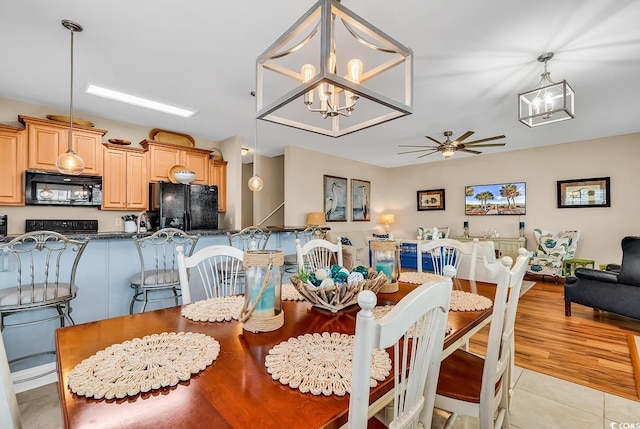 dining area with light tile patterned floors and ceiling fan with notable chandelier