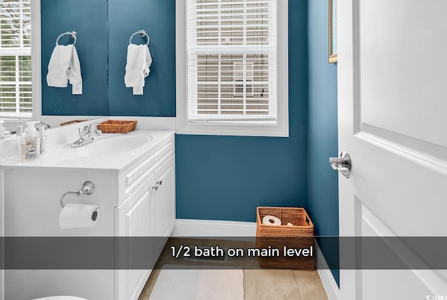 bathroom with vanity, baseboards, and tile patterned flooring