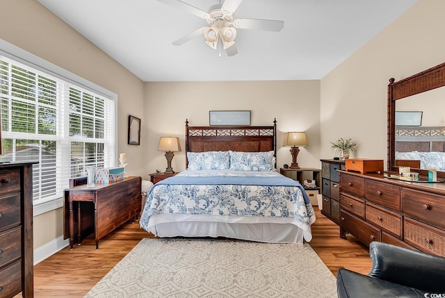 bedroom featuring baseboards, light wood finished floors, and ceiling fan