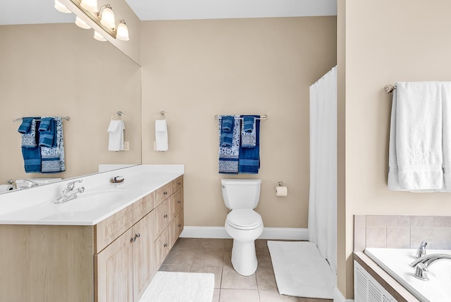 bathroom with vanity, toilet, baseboards, tile patterned floors, and a tub to relax in