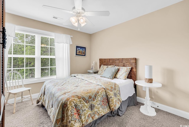 carpeted bedroom with baseboards, a ceiling fan, and visible vents