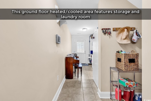 hall featuring light tile patterned floors and baseboards