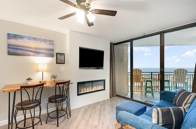5523 N Ocean Blvd Unit 1201, Myrtle Beach, SC 29577 - living room with floor to ceiling windows, wood finished floors, a ceiling fan, and a glass covered fireplace