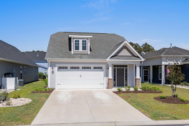 craftsman-style home featuring central air condition unit, driveway, roof with shingles, and a front lawn