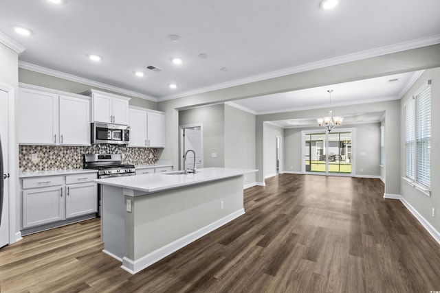 kitchen featuring a notable chandelier, appliances with stainless steel finishes, a sink, dark wood finished floors, and backsplash