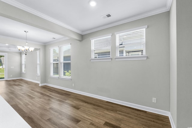 empty room with dark wood-style flooring, visible vents, crown molding, baseboards, and a chandelier