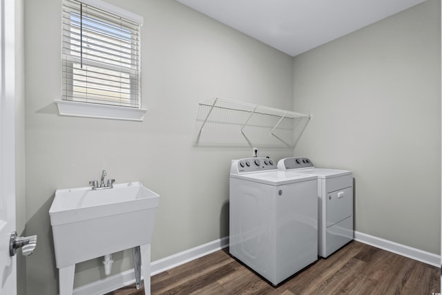 washroom with baseboards, laundry area, washer and clothes dryer, and dark wood-type flooring