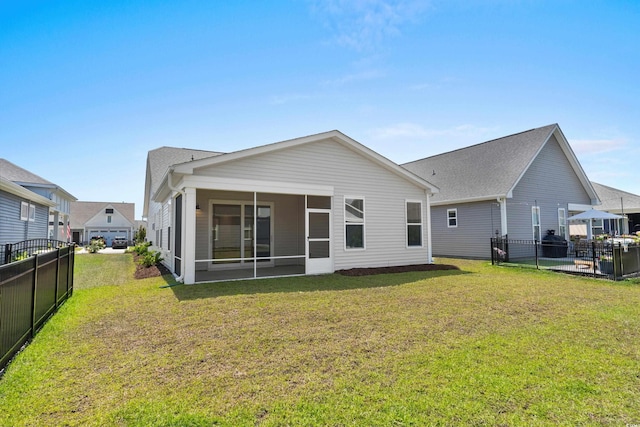 rear view of property featuring a lawn, fence, and a sunroom