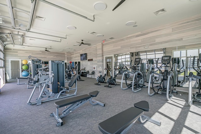 gym featuring wooden walls, visible vents, and carpet