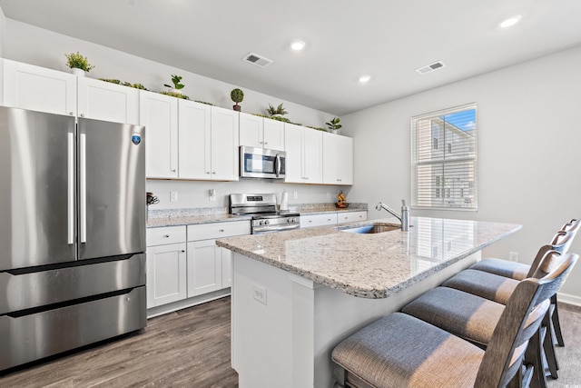 3968 Hibiscus Dr, Little River, SC 29566 - kitchen with appliances with stainless steel finishes, a sink, dark wood-type flooring, white cabinetry, and recessed lighting