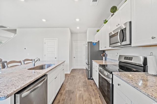 3968 Hibiscus Dr, Little River, SC 29566 - kitchen featuring appliances with stainless steel finishes, a sink, white cabinetry, and recessed lighting