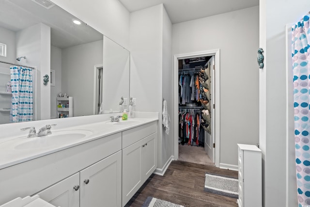 3968 Hibiscus Dr, Little River, SC 29566 - full bathroom featuring double vanity, wood finished floors, a walk in closet, curtained shower, and baseboards
