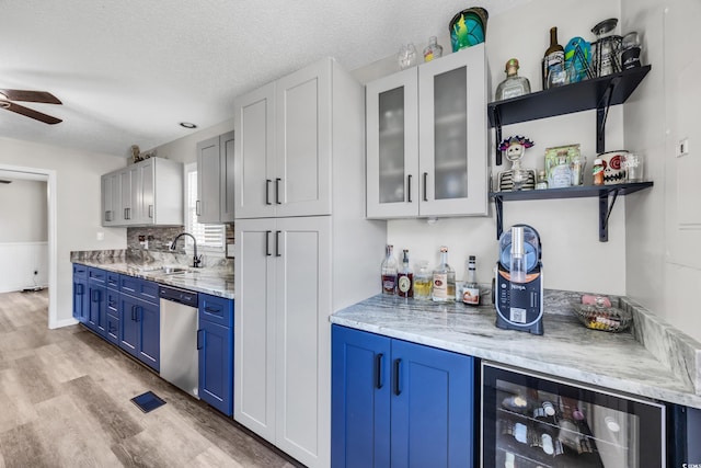 bar with ceiling fan, a dry bar, stainless steel dishwasher, a sink, and beverage cooler