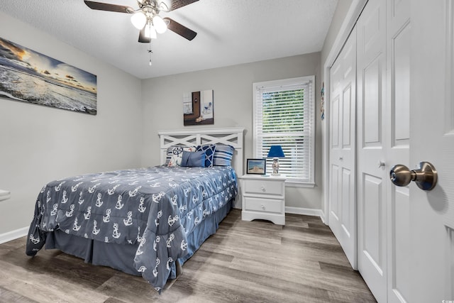 bedroom with a closet, baseboards, and wood finished floors